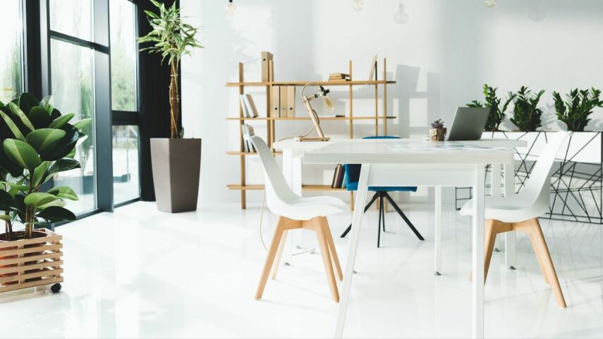Wnętrze mieszkania utrzymane w bieli ze stołem i krzesłami na pierwszym planie