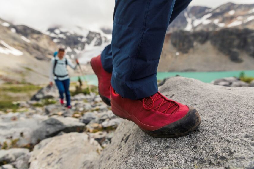 Na skale widok na nogi w zaawansowanych butach sportowych Arcteryx czerwonych