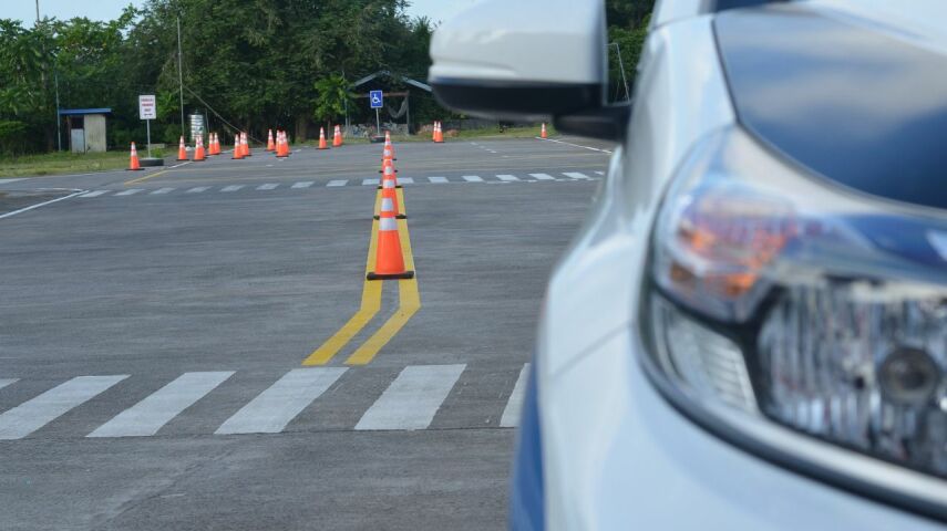 Widok części maski srebrego samochodu na placu manewrowym w tracie kursu na prawo jazdy