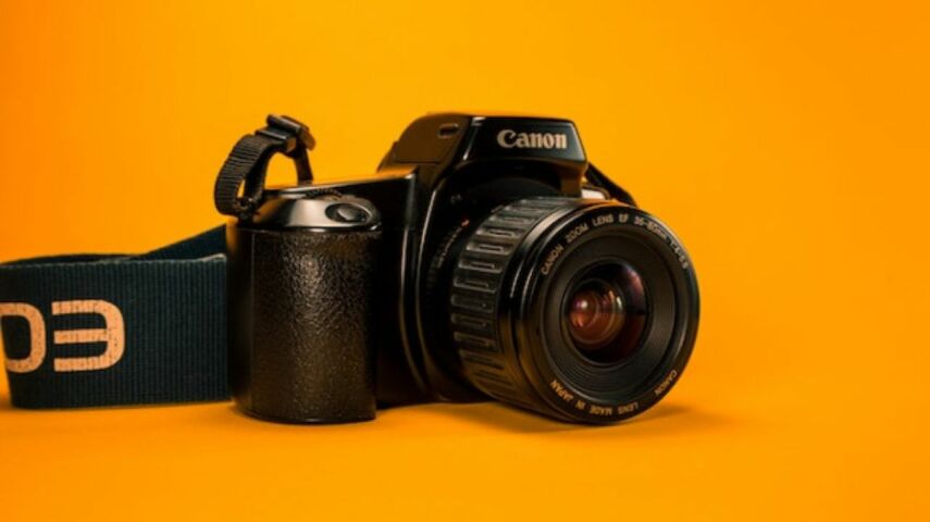 Czarny aparat fotograficzny profesjonalny na żółtym tle
