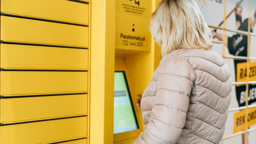 Kobieta nadaje lę w automacie Paczkomat InPost